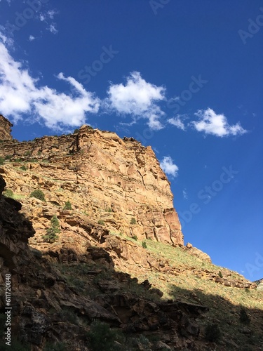 Beautiful mountains with deep blue skies and a few puffy clouds up 9 Mile Canyon, Helper, Utah. warm golden hour light illuminates a mountain cliff in the late afternoon, Nine Mile Canyon, Utah.