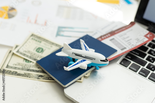 Air tickets, passports, money and toy plane on table