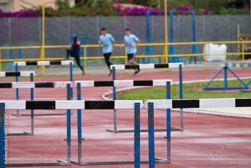 Synthetic running track for sporting events with hurdles