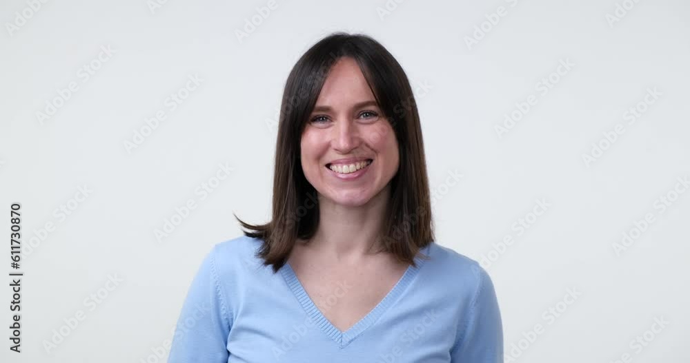 A beautiful Caucasian woman stands on a white background, flashing a bright, genuine smile. Her teeth are visible as she looks directly into the camera, radiating positivity and joy. A beautiful Caucasian woman stands on a white background, flashing a bright, genuine smile. Her teeth are visible as she looks directly into the camera, radiating positivity and joy.