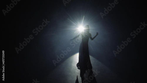 Girl dancing with chiffon fabric. Contemporary dance at smoky stage with spotlights. photo