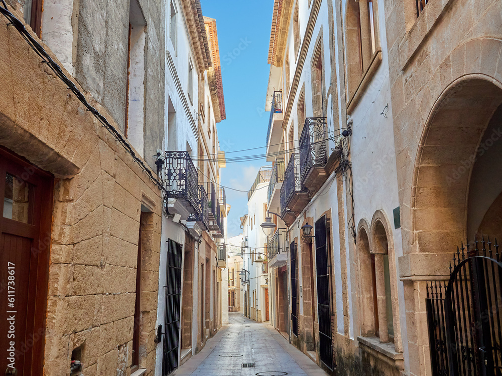 Fototapeta premium Narrow alley in the historical city centre of Javea. Jávea, Xàbia in Valencian. Marina Alta, Costa Blanca, Province of Alicante, Comunidad Valenciana, Spain, Europe