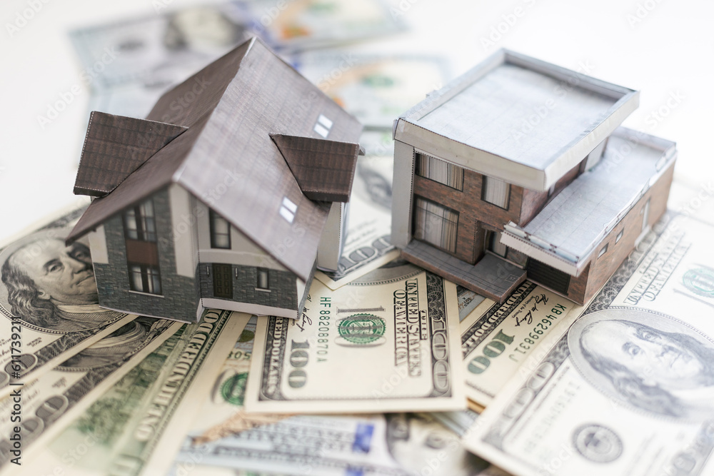 House model on 100 US dollar bills. Keep money or investment for building a new house House model on 100 US dollar bills. Keep money or investment for building a new house