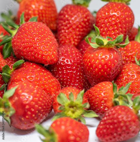 Beautiful red ripe strawberries are seen harvested on a white background and ready to be consumed.