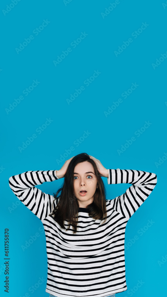 Excited Woman in Striped Sweater Celebrating Super Sale with Hands Raised, Energetic and Joyful Female Shopper Expressing Happiness - Isolated Blue Background - Perfect for Advertising and Promotions