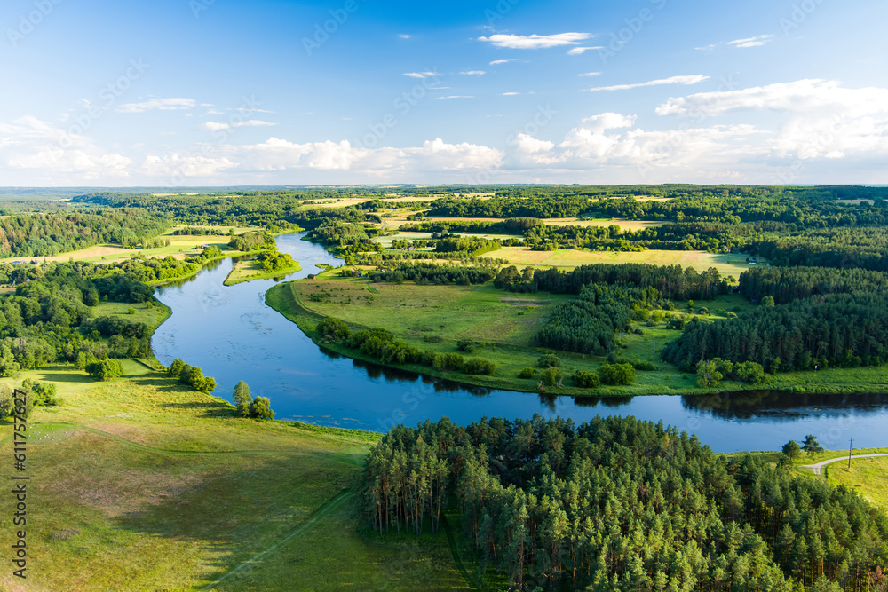 Scenic view of beautiful green Lithuanian countryside with a river in a distance.