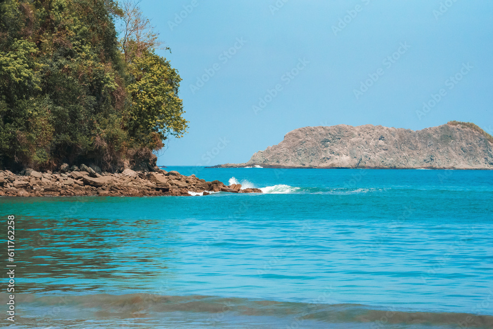 Scenic view of cliff surrounded with beautiful pacific ocean under clear blue sky during sunny day at Costa Rica, nature and travel concept