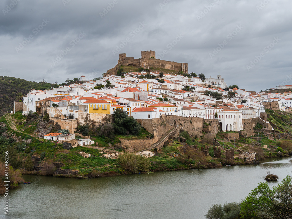 View on the historical walled city of Mertola on a hill at the banks of the Guadiana river in the south of Portugal
