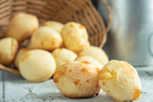 Cheese bread, Basket with cheese bread lying on a white lace tablecloth and accessories, dark background, selective focus.