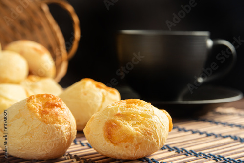 Cheese bread, Basket with cheese bread lying on a wooden woven mat and accessories, dark background, selective focus. photo