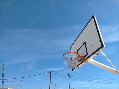 Fotografie basketball hoop seen from the basketball court in the background blue sky with s