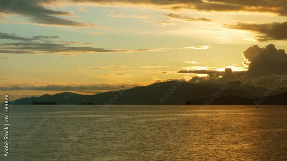 Time Lapse of the sun setting behind the mountains and the ocean. Time Lapse of the sun setting behind the mountains and the ocean.