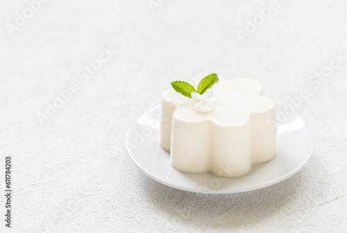 Wallpaper Mural Vanilla cream pudding, Panna Cotta, decorated with white flower. On a plate. White background. Copy space Torontodigital.ca