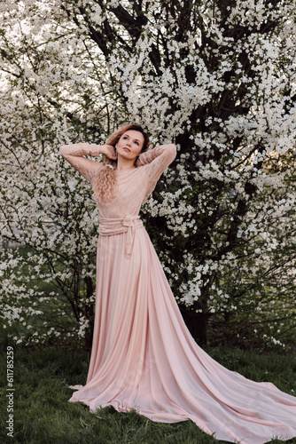 A beautiful woman in a spring garden near cherry blossoms. Flowering garden © Ирина Санжаровская