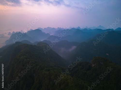 Aerial top view of forest trees and green mountain hills with fog, mist and clouds. Nature landscape background, Vietnam. © tampatra