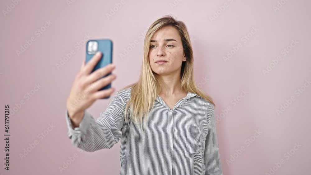 Young blonde woman smiling confident making selfie by the smartphone over isolated pink background Young blonde woman smiling confident making selfie by the smartphone over isolated pink background