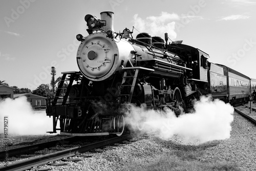 Vintage steam train in black and white blowing steam