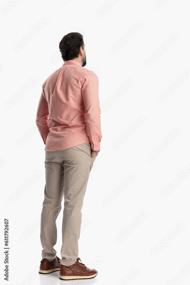 back view of smart casual guy holding hands in pockets and standing back view of smart casual guy holding hands in pockets and standing