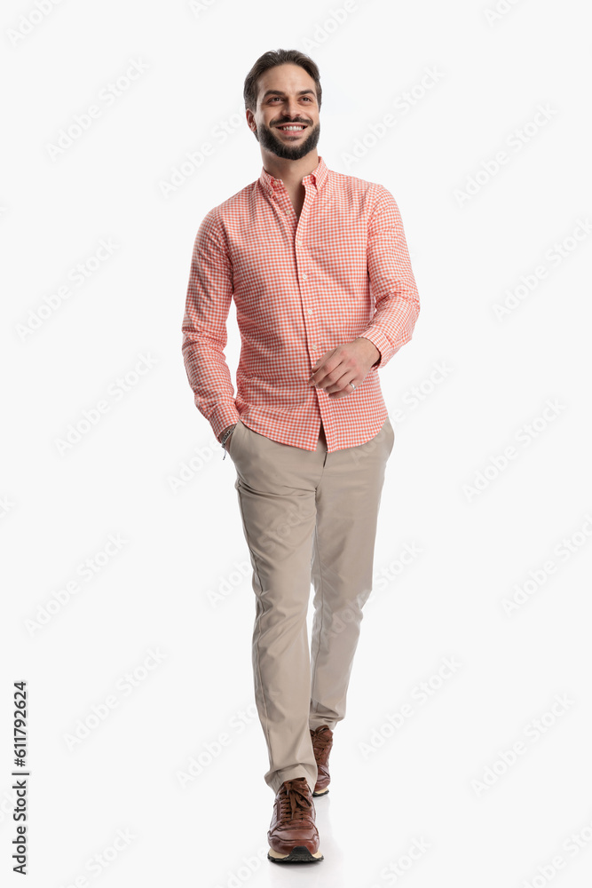 happy young man in plaid shirt walking with hand in pocket and looking up happy young man in plaid shirt walking with hand in pocket and looking up