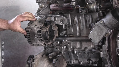 Tightening the Alternator Charger Screws of the Faulty Old Car Engine in the Repair Shop Footage.