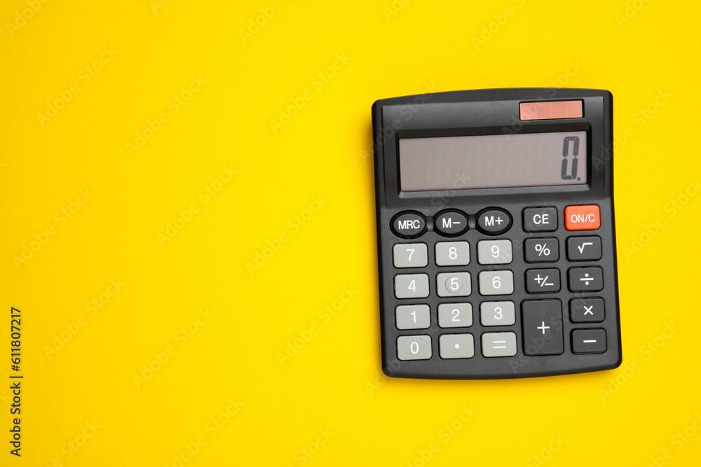 Black calculator on yellow background, top view. Space for text Black calculator on yellow background, top view. Space for text