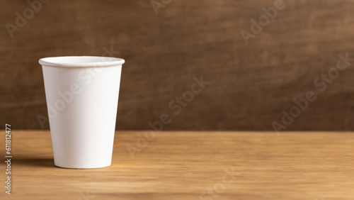 One eco-friendly cardboard cup on a wooden background. The concept of eco-friendly, purity. Mock-up. Copy space. - generative ai