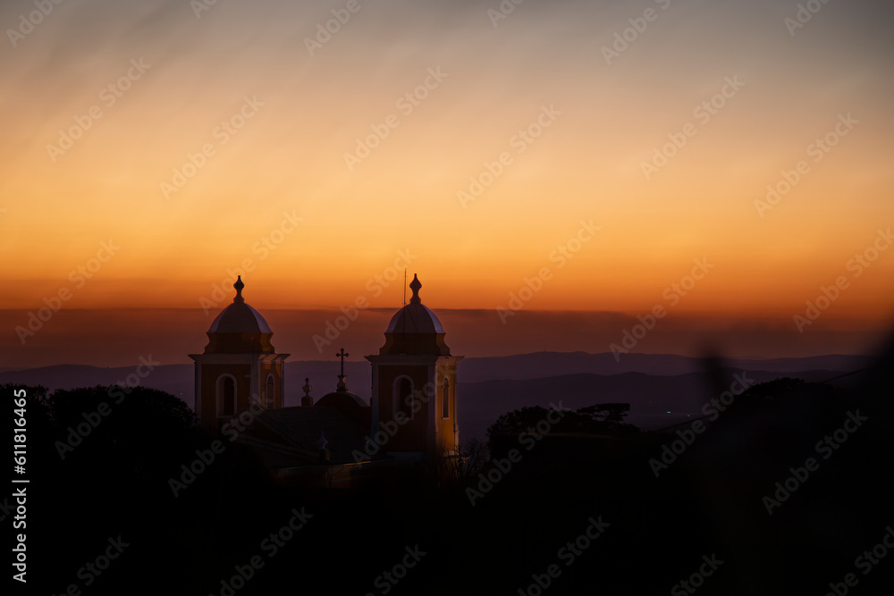 Pôr do Sol com montanhas e arquitetura das Torres da Igreja Matriz da cidade de São Thomé das Letras, Minas Gerais
