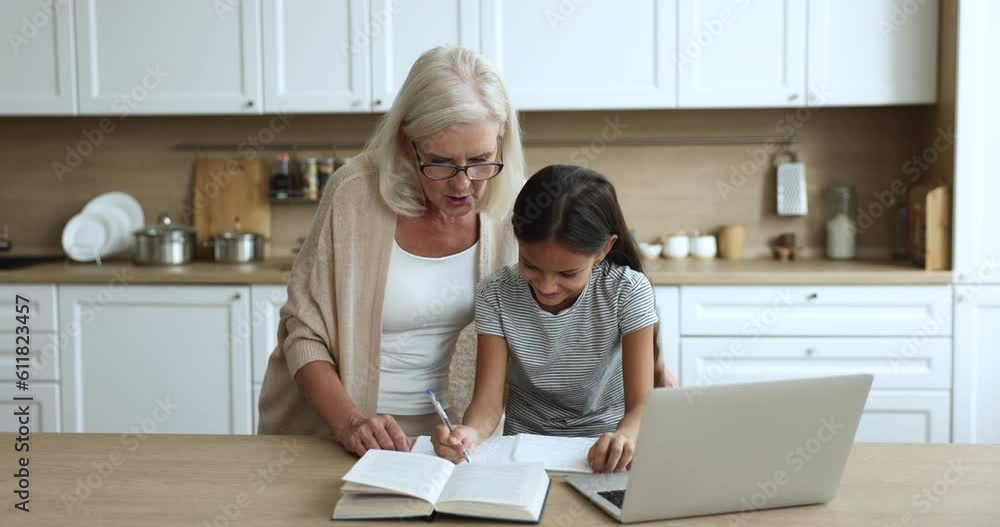 Loving retired 60s granny explaining homework to pretty little 10s