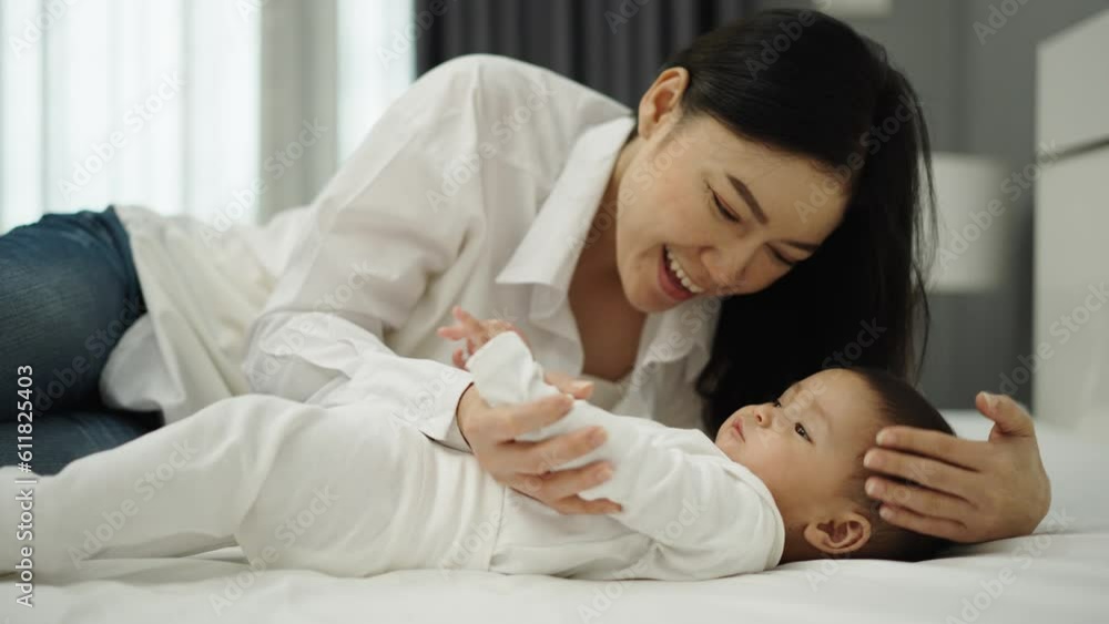 mother kissing her infant baby on a bed mother kissing her infant baby on a bed