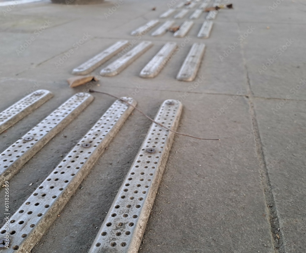 Fototapeta premium tactile warning strip for the visually impaired on the sidewalk. Tactile ground surface indicators for blind and visually impaired. Detectable warnings outside