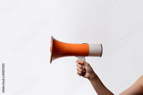 The hand holds a orange megaphone on a white background. Announcement concept. Shout It Out