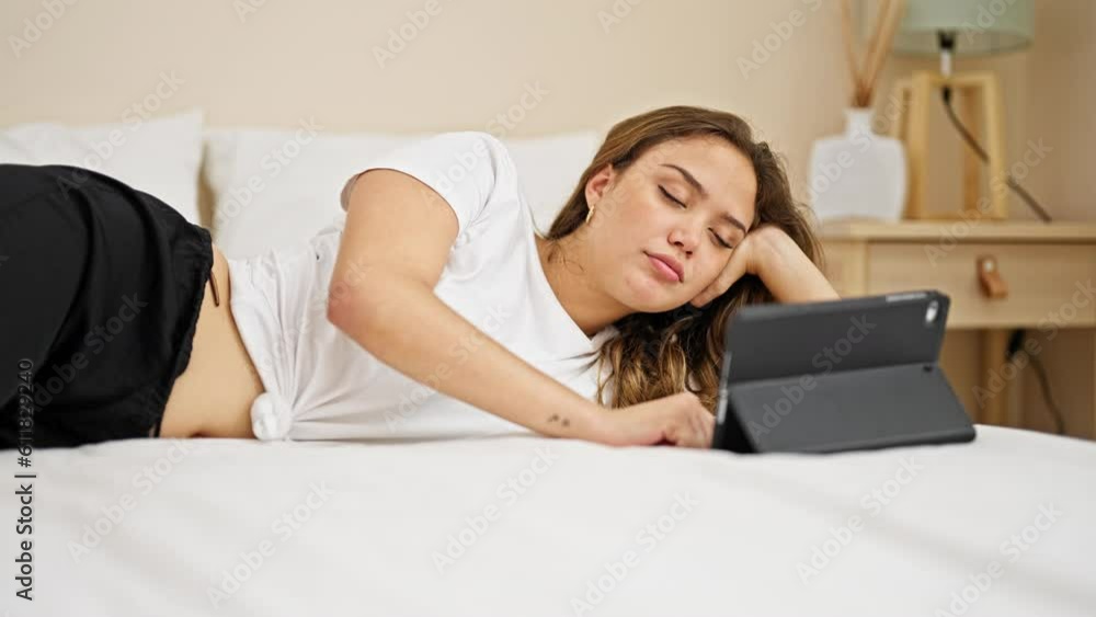 Young beautiful hispanic woman using touchpad lying on bed at bedroom Young beautiful hispanic woman using touchpad lying on bed at bedroom