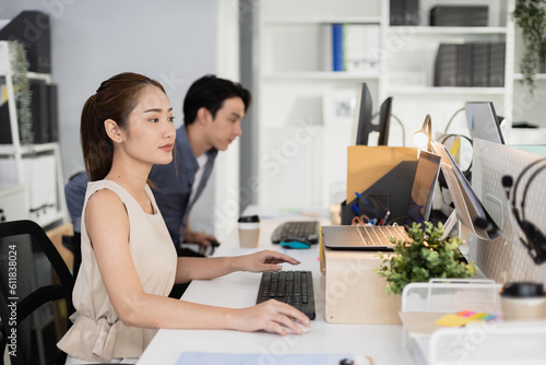 Young asian businesswoman using laptop at office table. company employees sitting at work, Accounting staff working towards marketing.