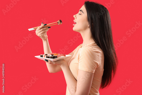 Young woman eating sushi ro...