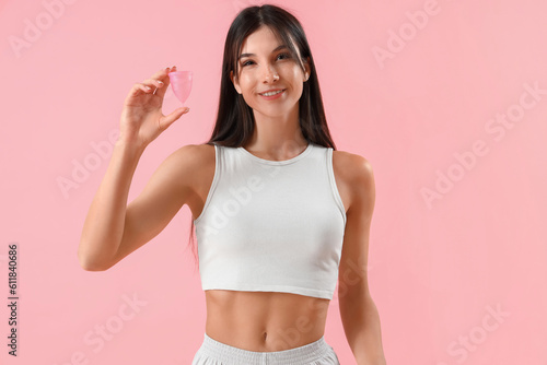 Young woman with menstrual cup on pink background © Pixel-Shot