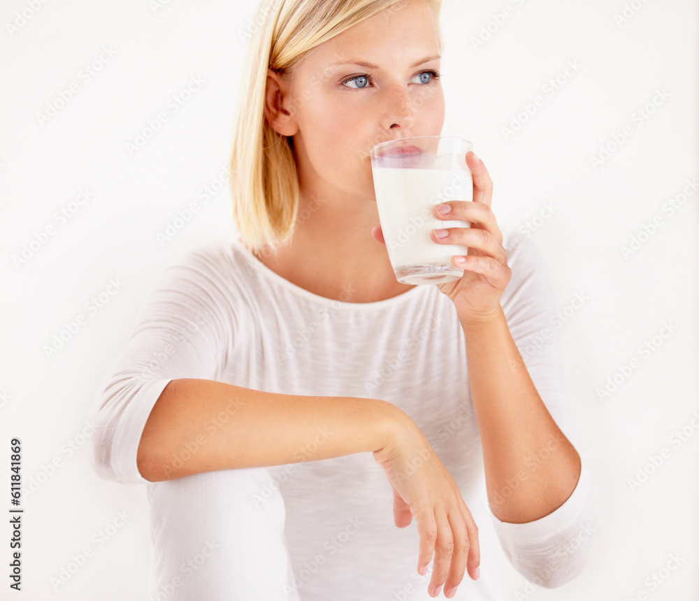 Thinking, milk and calcium with a woman drinking from a glass in studio isolated on a white background. Diet, nutrition and detox with a healthy young female enjoying a drink for vitamins or minerals Thinking, milk and calcium with a woman drinking from a glass in studio isolated on a white background. Diet, nutrition and detox with a healthy young female enjoying a drink for vitamins or minerals