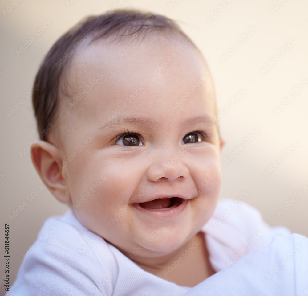 Happy, closeup face of a baby with a smile and health wellness for childhood development. Happiness or excited, childhood or giggle for fun and toddler smiling for healthcare with laugh for comedy