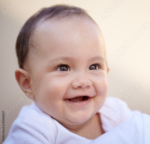 Happy  closeup face of a baby with a smile and health wellness for childhood development. Happiness or excited  childhood or giggle for fun and toddler smiling for healthcare with laugh for comedy