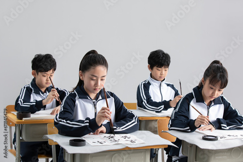 Students practicing calligraphy in classroom photo