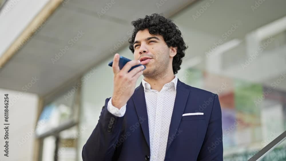 Young latin man business worker sending voice message by smartphone at street Young latin man business worker sending voice message by smartphone at street