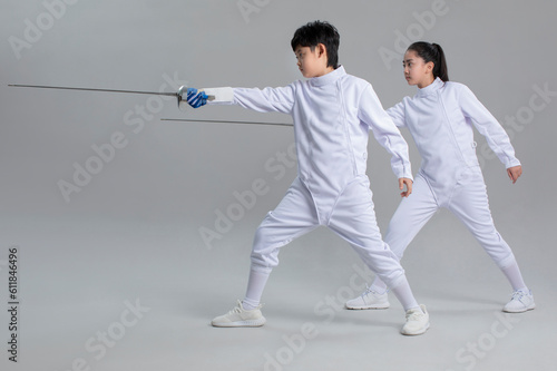 Cute girl and boy in fencing suit photo