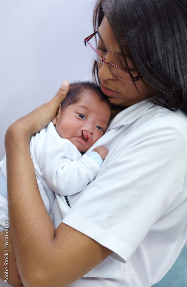 Medicine, cleft lip and a pediatrician with a baby in the hospital for healthcare, insurance or treatment. Medical, children and a doctor woman holding a newborn infant with a disability in a clinic Medicine, cleft lip and a pediatrician with a baby in the hospital for healthcare, insurance or treatment. Medical, children and a doctor woman holding a newborn infant with a disability in a clinic