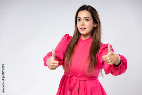 Confident indian woman showing thump up on white background.
