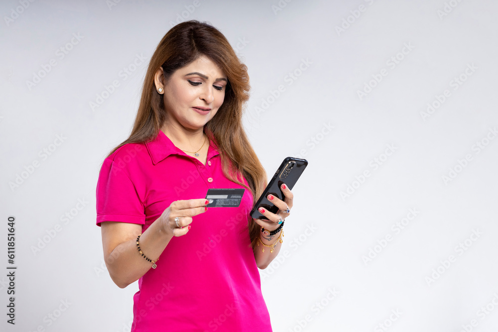 Indian woman using smartphone with bank card. Indian woman using smartphone with bank card.
