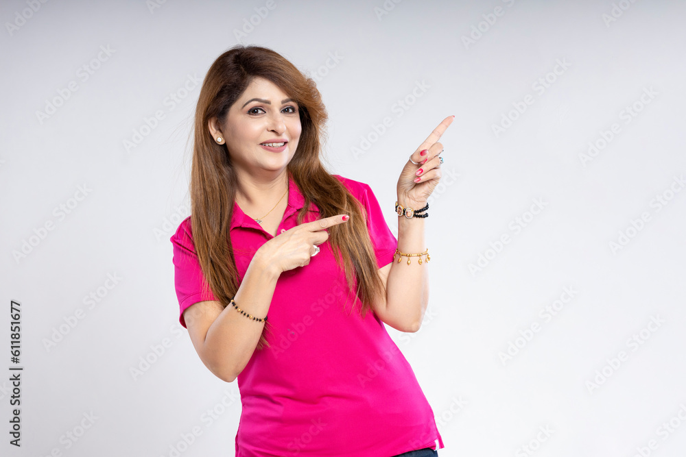 Indian woman showing finger on empty space and giving happy expression. Indian woman showing finger on empty space and giving happy expression.