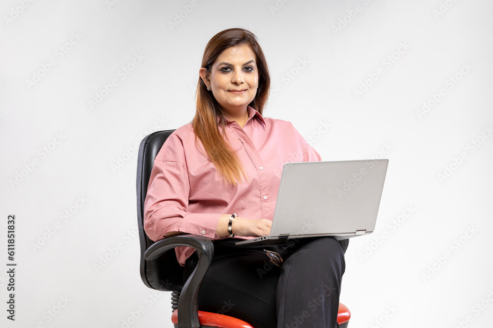 Indian woman sitting on chair and using laptop. Indian woman sitting on chair and using laptop.
