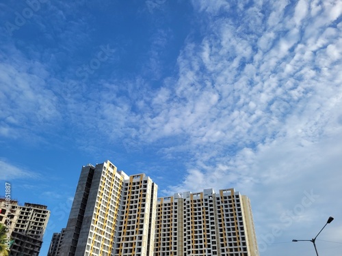 Low-angle view of under-construction residential buildings against blue sky