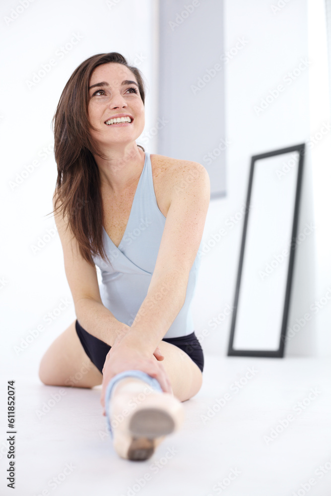Fototapeta premium Stretching legs, ballet and woman workout in studio sitting on floor. Ballerina, stretch and happy athlete warm up for exercise, creative dance or fitness, training and thinking of theatre practice.