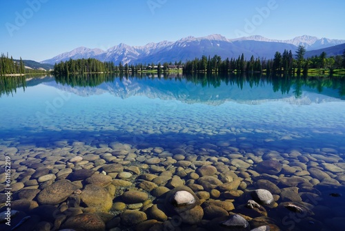 Glassy, transparent blue waters of Lake Beauvert near Jasper in the Canada Rockies