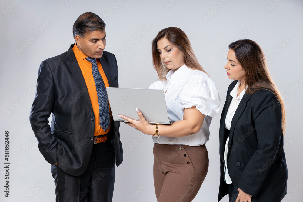 Indian businesspeople using laptop while discussing some topic Indian businesspeople using laptop while discussing some topic